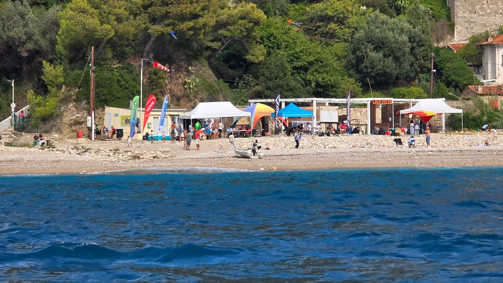 Le village de Roq'Acro installé sur la plage de galets du Golfe Bleu, vu depuis la mer